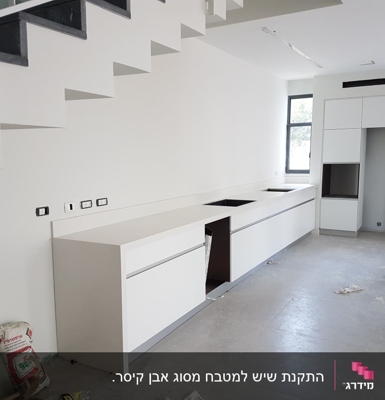 שיש לבן מותקן במטבח חדש תחת מדרגות